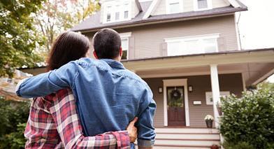 couple standing in front of house