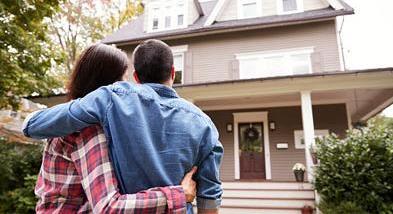 couple standing in front of house